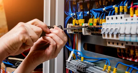 Commercial electrician performing electrical maintenance at a Hawke’s Bay business